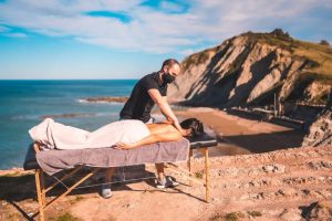 Personne allongée sur une table de massage pendant un soin californien enveloppant